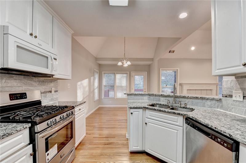655 Golden Meadows Lane Suwanee, GA 30024 - Photo 25 of 73 a kitchen with stainless steel appliances granite countertop a stove a sink and a microwave
