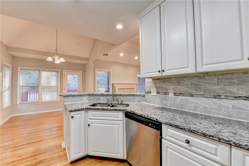 655 Golden Meadows Lane Suwanee, GA 30024 - Photo 26 of 73 a kitchen with granite countertop a sink a stove and cabinets