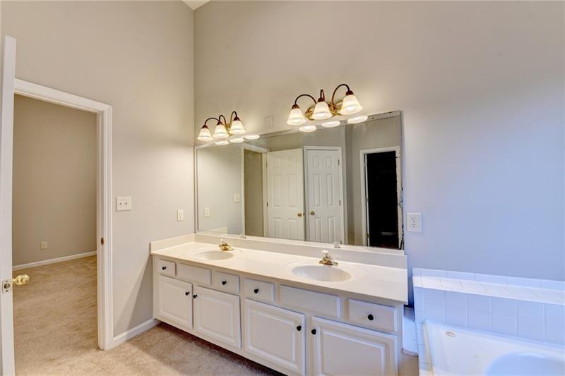 655 Golden Meadows Lane Suwanee, GA 30024 - Photo 36 of 73 a bathroom with a double vanity sink and a mirror