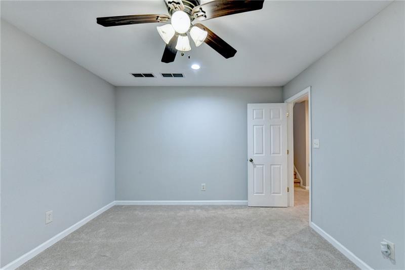655 Golden Meadows Lane Suwanee, GA 30024 - Photo 57 of 73 an empty room with a chandelier fan and a ceiling fan