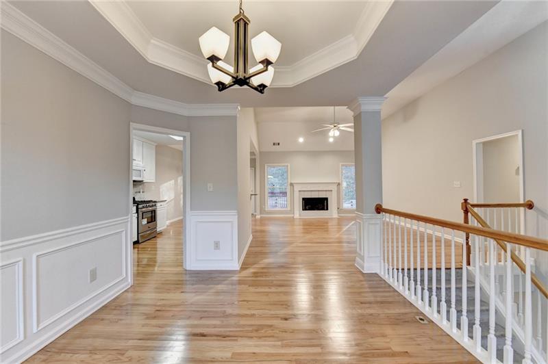 655 Golden Meadows Lane Suwanee, GA 30024 - Photo 10 of 73 a view of a hallway with wooden floor and chandelier