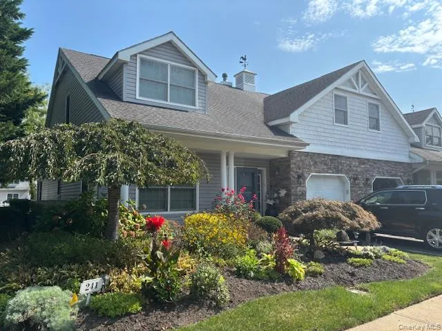 a front view of a house with a yard and potted plants