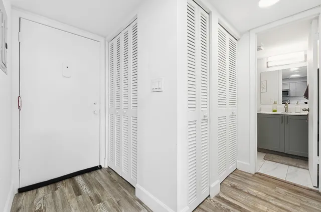 a view of a hallway with closet and wooden floor