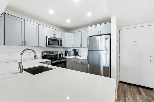 a kitchen with refrigerator a microwave a sink and cabinets