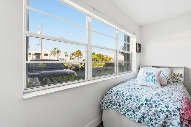 a bedroom with a bed and a large window