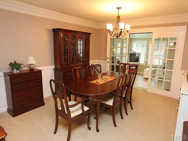 FORMAL DINING ROOM WITH RAISED PANEL SURROUND, LARGE CEILING DENTAL MOLDINGS WITH GLASS DOORS OPEINING ONTO PORCH