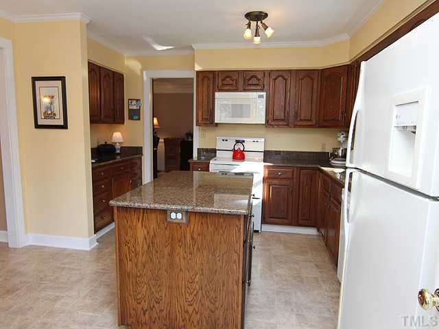 8312 Kestrel Drive Raleigh, NC 27615 - Photo 11 of 24 LARGE ISLAND WITH PLENTY OF CABINETS FOR COOKING OR SERVING. SERVING BUFFET AREA TO LEFT HAS WONDERFUL CABINETS AND DRAWERS FOR ADDITIONAL SPACE.