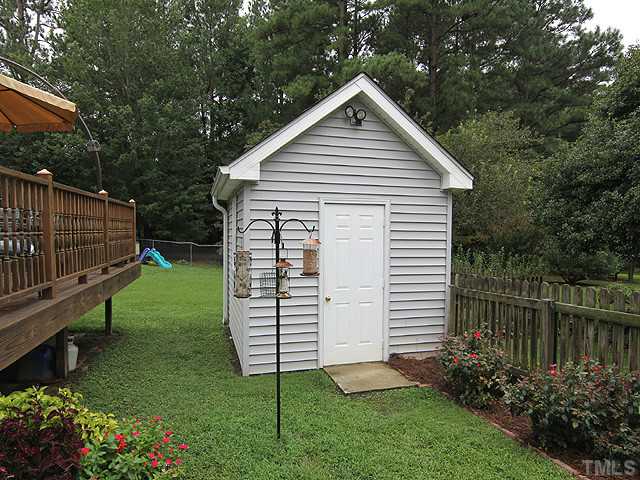 8312 Kestrel Drive Raleigh, NC 27615 - Photo 22 of 24 THE LOVELY WOODEN DECK OFF THE PORCH IS A NATURAL PICK FOR GRILLING AND DINING OUT. BEAUTIFUL LANDSCAPED YARD WITH GRAPE TRELLIS, FRUIT TREES, AND HARDWOODS TO VIEW
