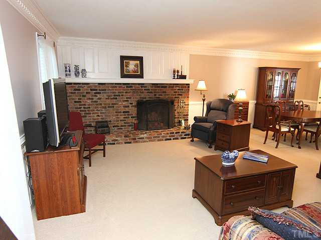 CUSTOM DETAILING WITH MANTLE OVERLAY AROUND FIREPLACE ALONG WITH CUSTOM PANELING SURROUNDING LIVING ROOM AND DINING ROOM.  BEAUTIFUL CEILING MOLDINGS EXTEND INTO CLASSIC OPENNESS OF FORMAL DINING ROOM