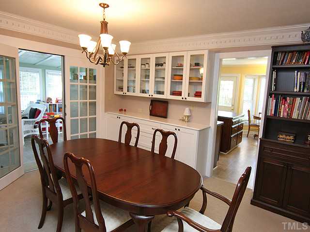 8312 Kestrel Drive Raleigh, NC 27615 - Photo 8 of 24 DINING ROOM BOASTS HANDSOME PANELS BELOW CHAIR RAIL AND LOVELY GLASS BUFFET GIVES THIS ROOM A WEALTH OF WARMTH. GLASS PANELED DOORS OPEN ONTO ENCLOSED PORCH FOR FAMILY ENJOYMENT