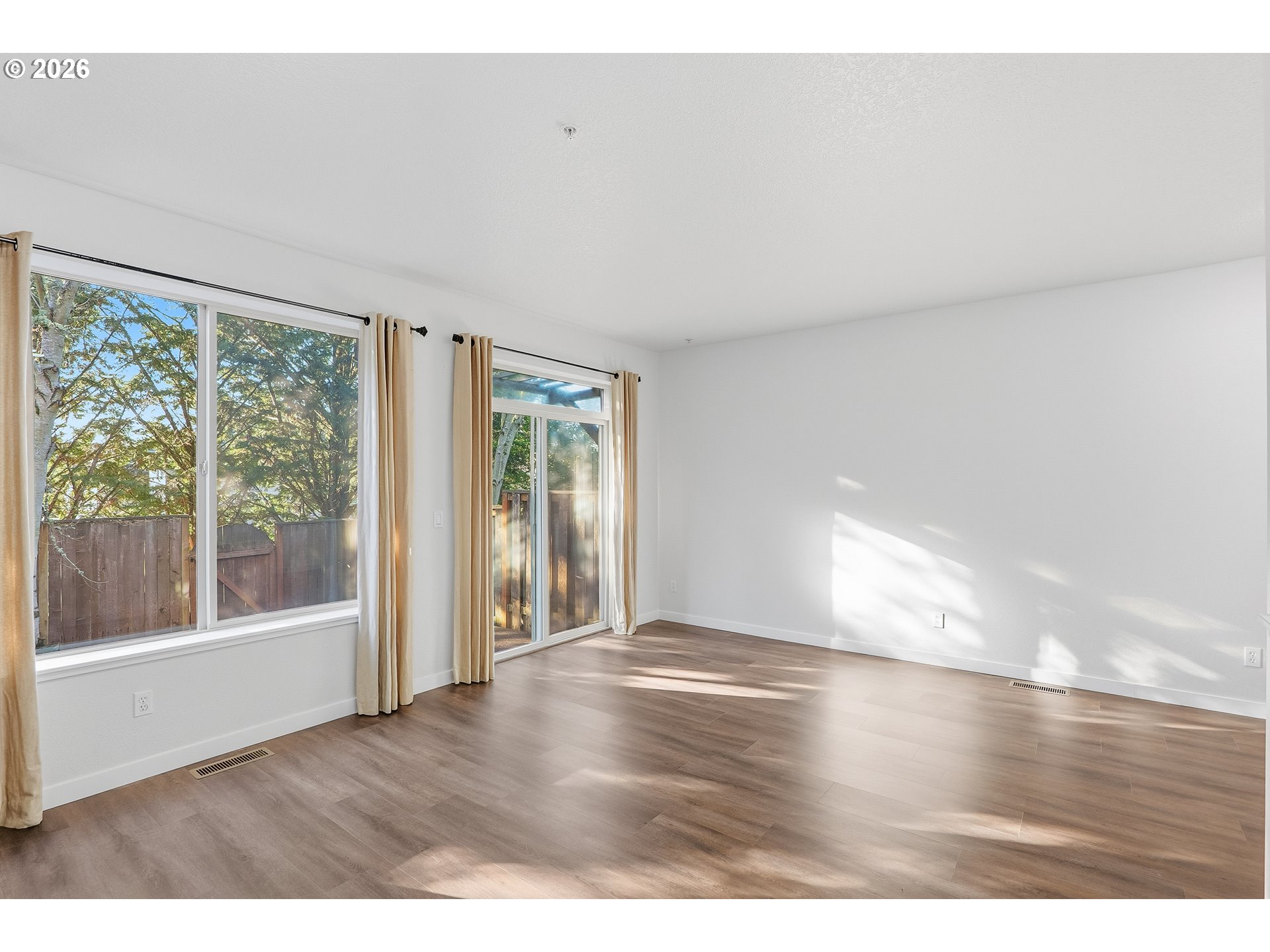16012 Northwest Centine Lane Portland, OR 97229 - Photo 9 of 24 a view of an empty room with wooden floor and a window