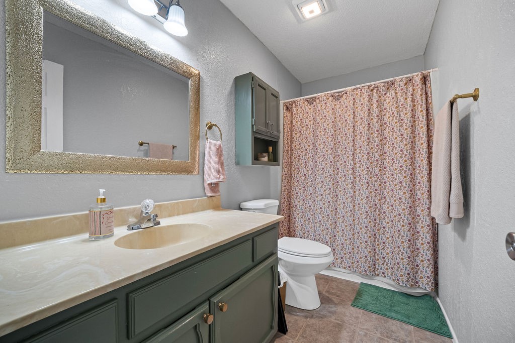 2302 Memorial Parkway Portland, TX 78374 - Photo 18 of 21 a bathroom with a sink a toilet a mirror and shower curtain