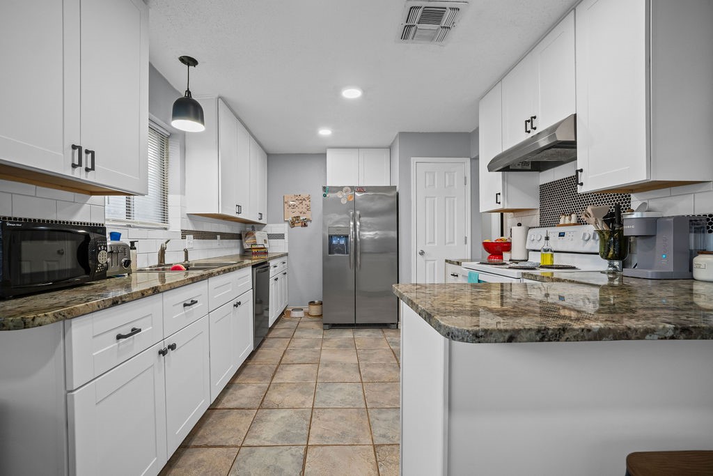 2302 Memorial Parkway Portland, TX 78374 - Photo 9 of 21 a kitchen with stainless steel appliances granite countertop a sink refrigerator and cabinets