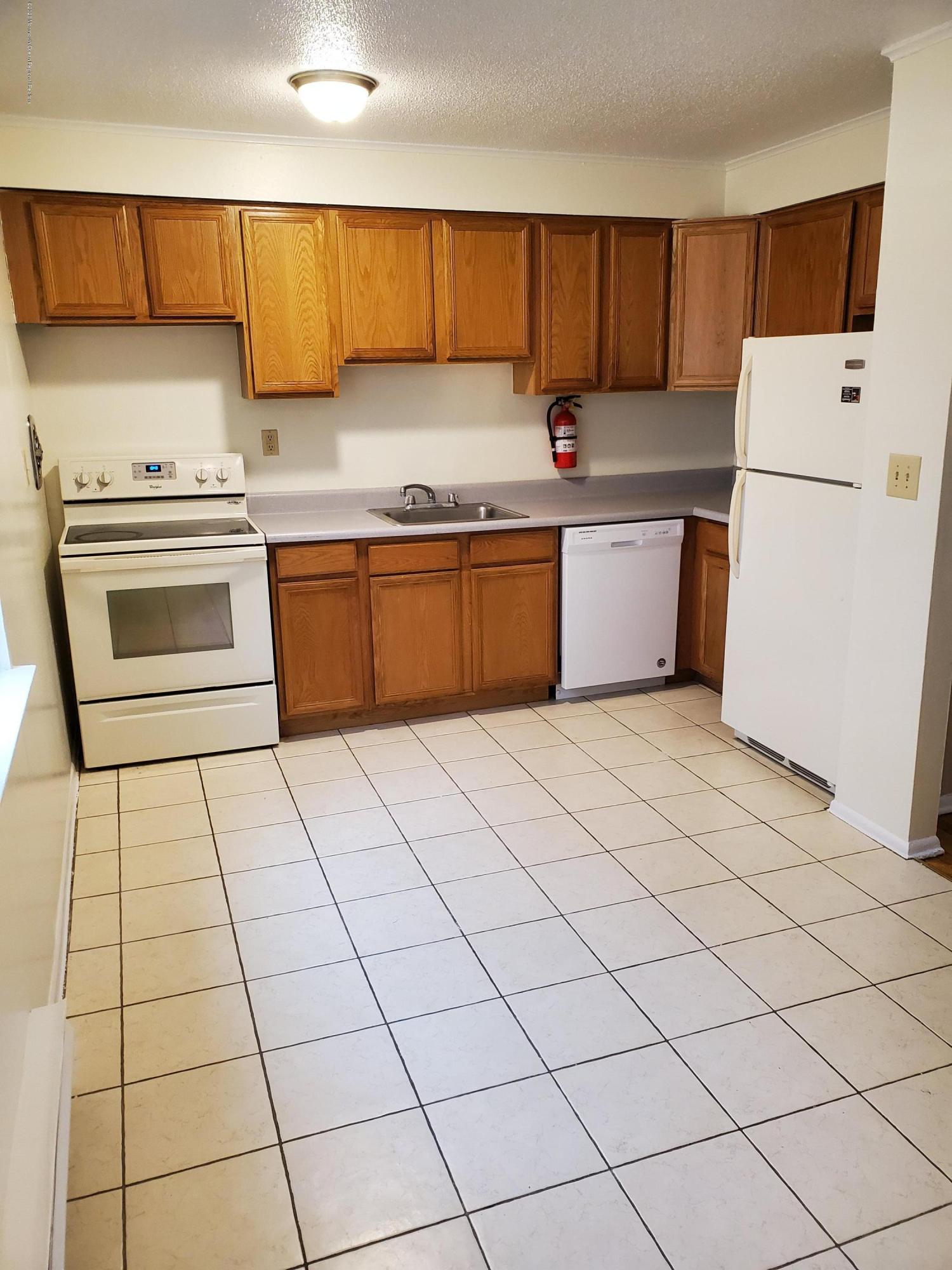 2 Sutton Drive, Unit P04 Matawan, NJ 07747 - Photo 7 of 8 a kitchen with a stove a sink and a refrigerator