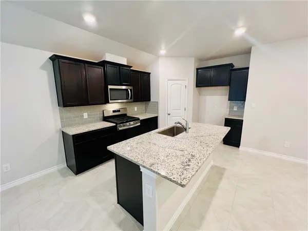 a kitchen with a refrigerator stove and microwave
