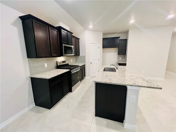a kitchen with granite countertop stainless steel appliances and sink