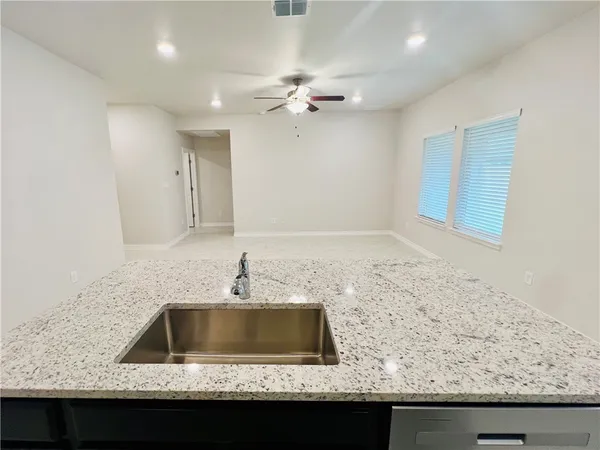 a kitchen with a sink a vanity and a refrigerator