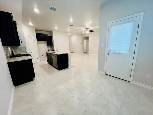 a large white kitchen with a stove a sink and a refrigerator