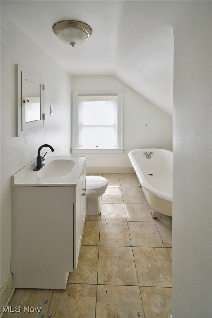17424 Winslow Road Cleveland, OH 44120 - Photo 34 of 45 Full bathroom featuring a freestanding bath, vanity, vaulted ceiling, and light tile patterned floors
