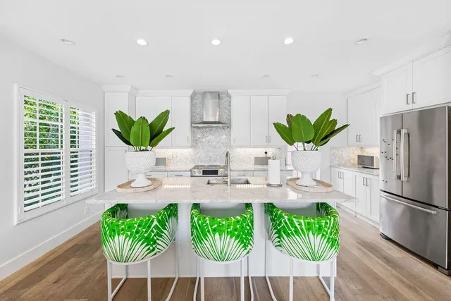 a kitchen with stainless steel appliances a table chairs in it and a window