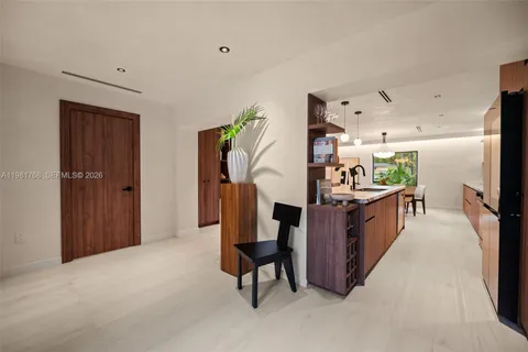 a kitchen with stainless steel appliances kitchen island granite countertop furniture a refrigerator and a view of living room