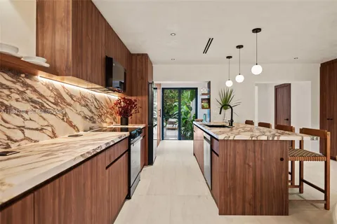 a kitchen with kitchen island granite countertop wooden cabinets a sink and a stove