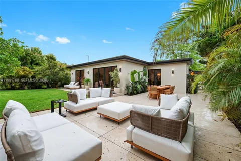 a view of a house with backyard sitting area and garden