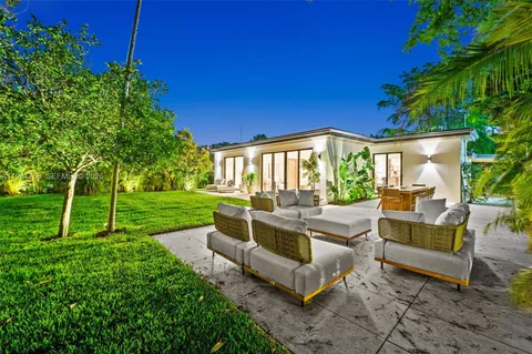 a view of backyard with seating area and green space