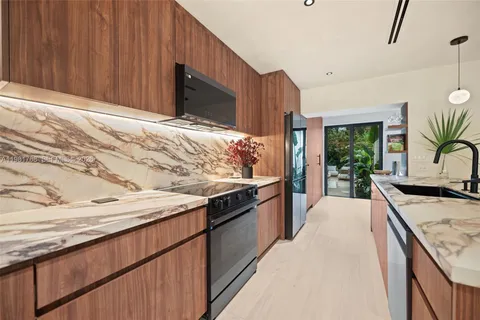a kitchen with stainless steel appliances granite countertop wooden cabinets a stove and a sink