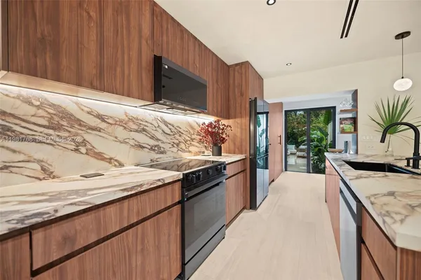 a kitchen with stainless steel appliances granite countertop wooden cabinets a stove and a sink