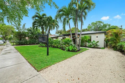 a front view of a house with a yard and potted plants