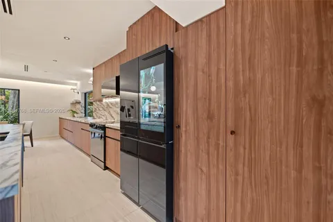 a kitchen with stainless steel appliances a refrigerator and a wooden cabinets
