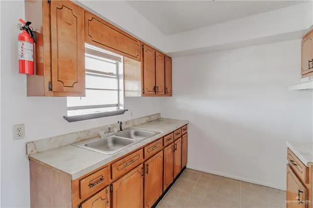 a utility room with a sink cabinets and a window