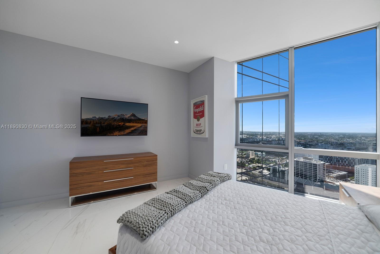 851 Northeast 1st Avenue, Unit 4401/4402 Miami, FL 33132 - Photo 21 of 37 a bedroom with furniture and a flat screen tv