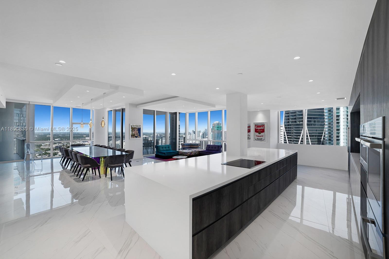 851 Northeast 1st Avenue, Unit 4401/4402 Miami, FL 33132 - Photo 3 of 37 a kitchen with kitchen island a large counter top dining table and chairs