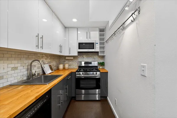 a kitchen with stainless steel appliances a stove sink microwave and cabinets