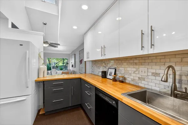 a kitchen with a sink a counter space appliances and cabinets