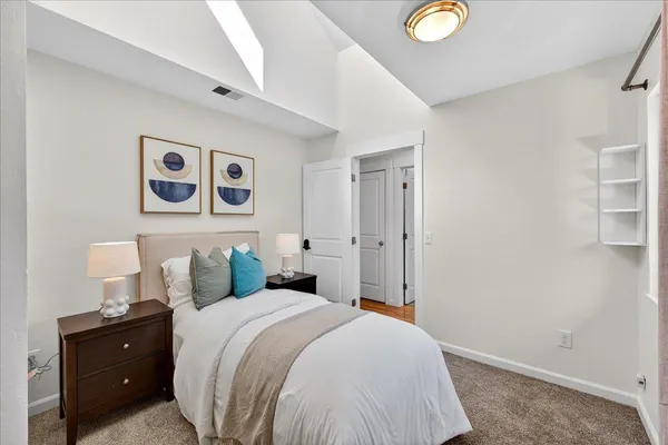 a bedroom with a bed and painting on the wall