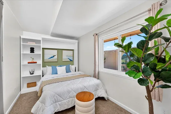 a bedroom with a bed and a potted plant