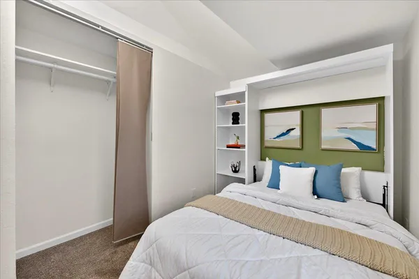 a bedroom with a bed and painting on the wall