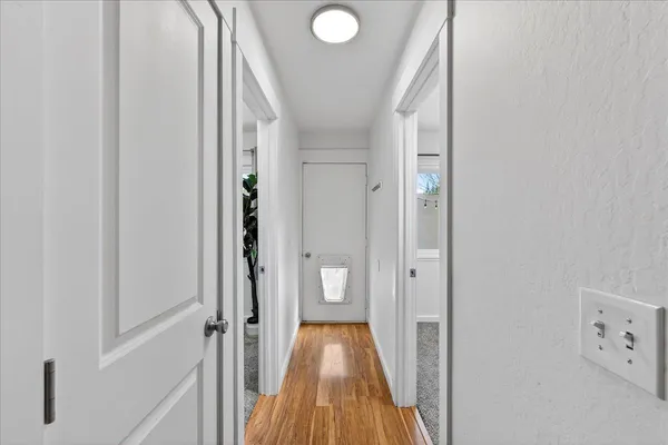a view of a hallway with wooden floor and staircase