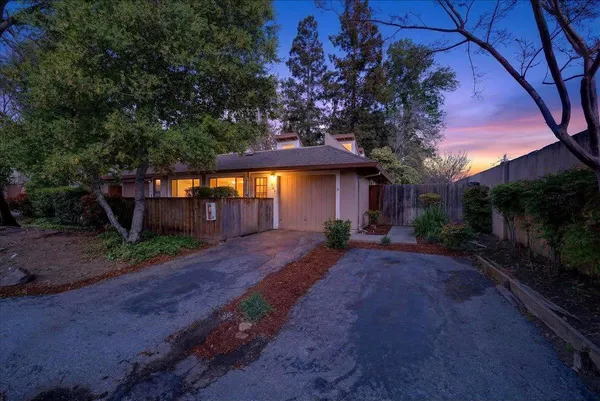 a view of a house with backyard and a tree