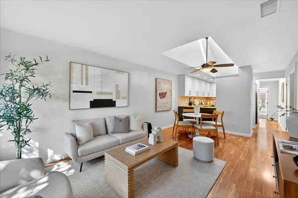 a living room with furniture kitchen view and a potted plant