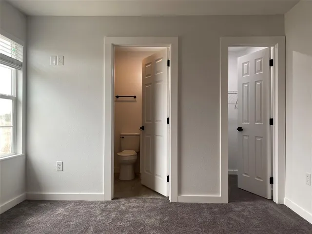 an empty room with windows and closet