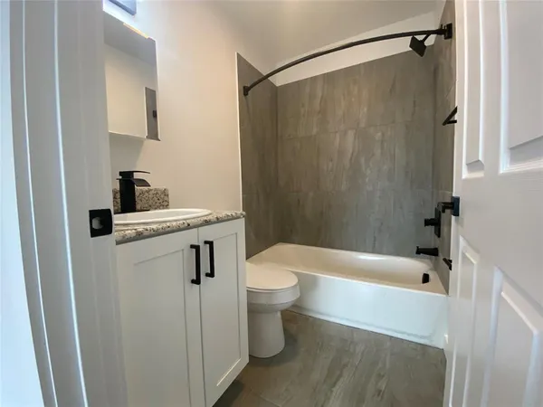 a white bath tub sitting next to a white toilet and sink