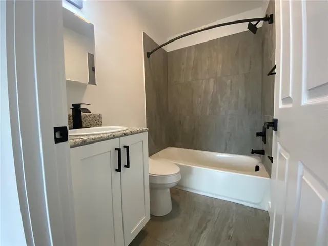 a white bath tub sitting next to a white toilet and sink