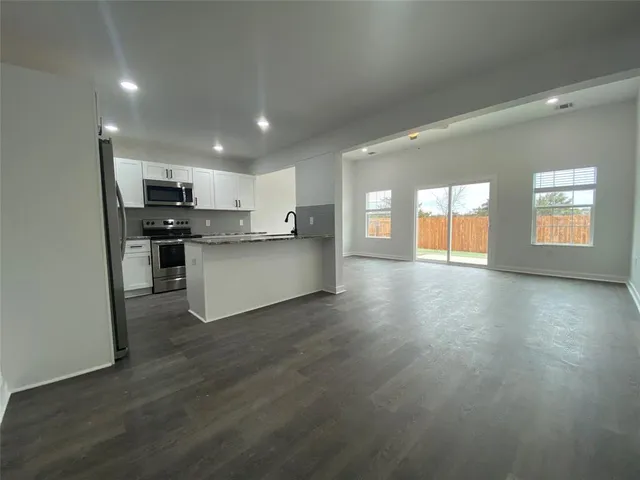 a view of a kitchen and an empty room