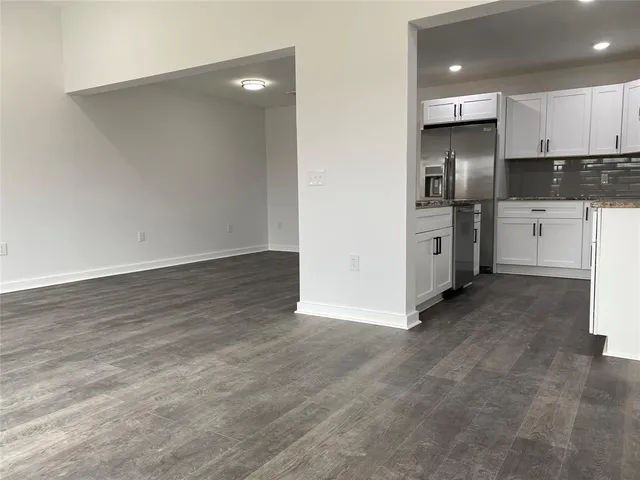 a view of kitchen with granite countertop cabinets and refrigerator