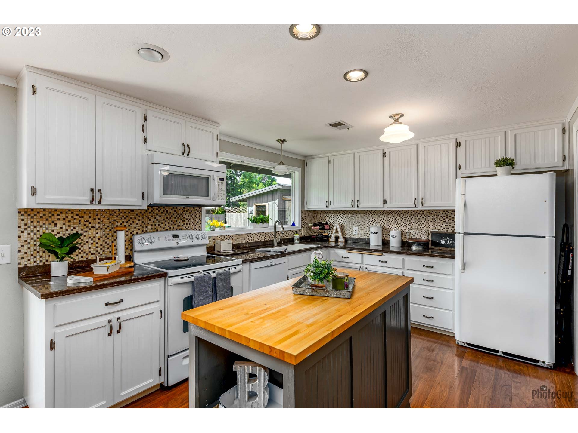 5621 C Street Springfield, OR 97478 - Photo 11 of 29 a kitchen with stainless steel appliances granite countertop a refrigerator a sink dishwasher a stove and white countertops with wooden floor