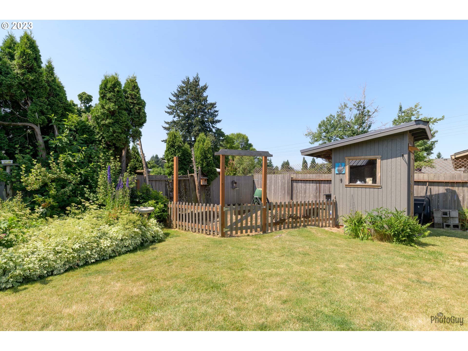 5621 C Street Springfield, OR 97478 - Photo 26 of 29 a garden with a bench in front of the house
